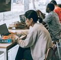 Line of students in cafe on laptops