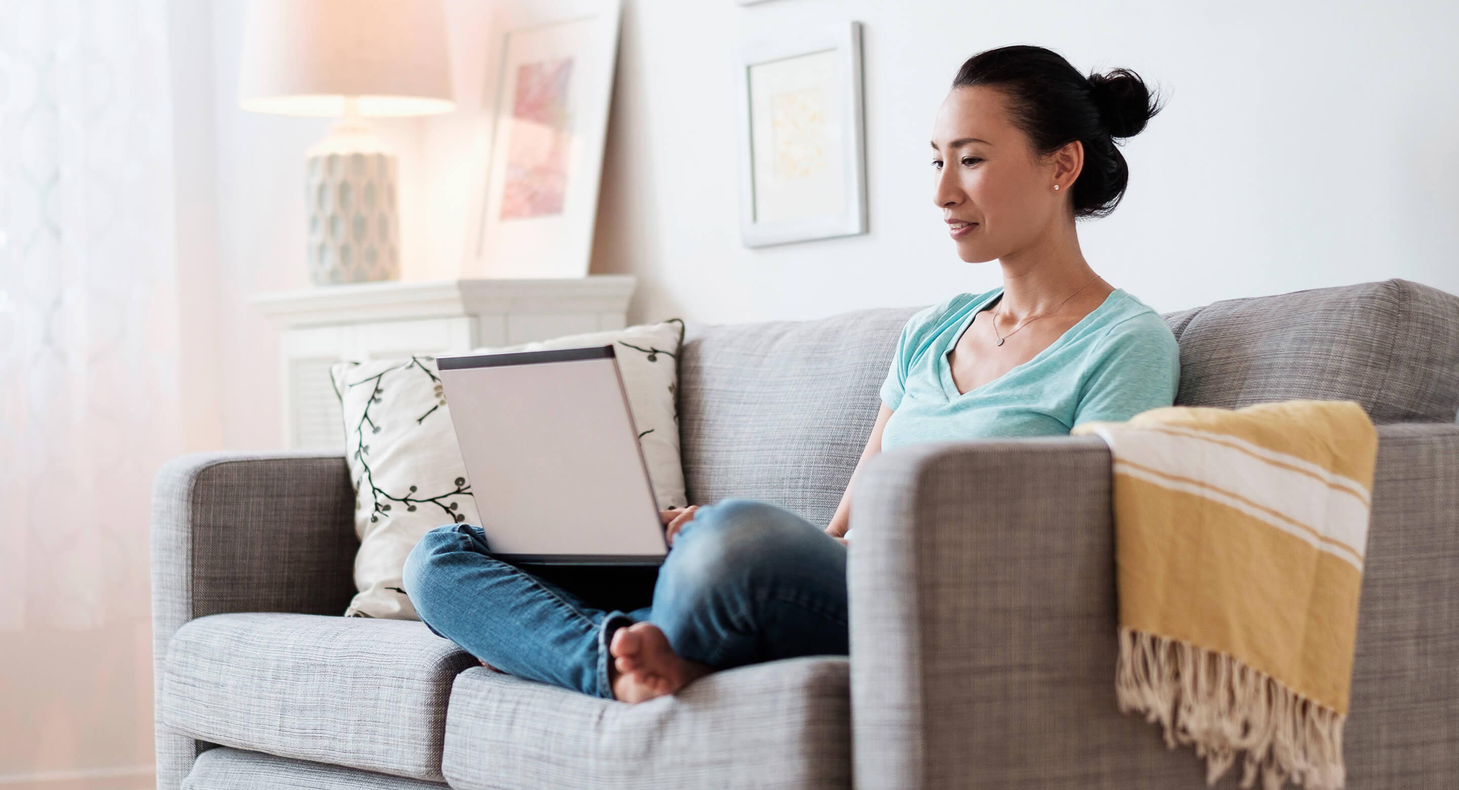 Woman using laptop on sofa