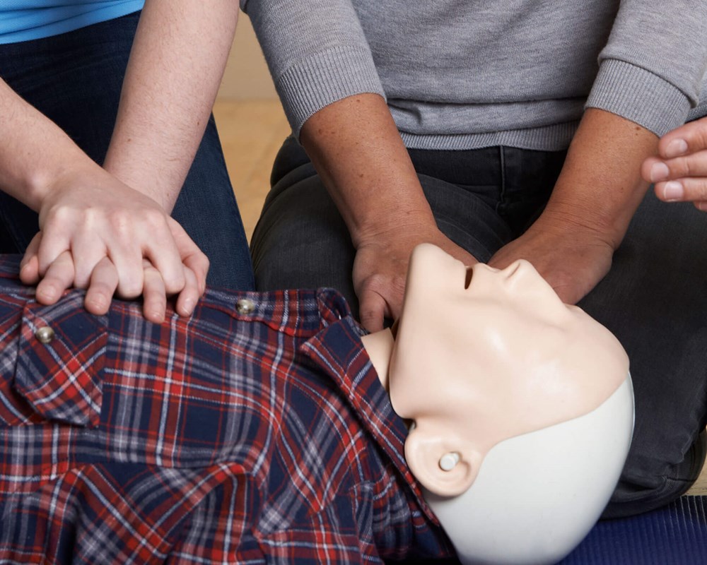Team CPR training on simulation dummy.