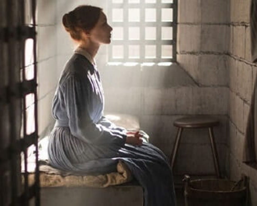 A scene in Alias Grace of Grace Marks sitting on her bed staring off into the distance.