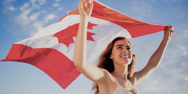 A woman holding the Canadian flag over her head.