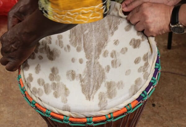 Someone putting drum skin over a drum.