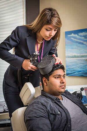 Dr. Faranak Farzan shows an example of  non-invasive brain stimulation therapy