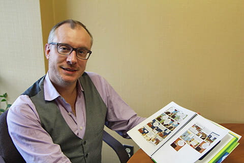A man with glasses showing the camera book. 