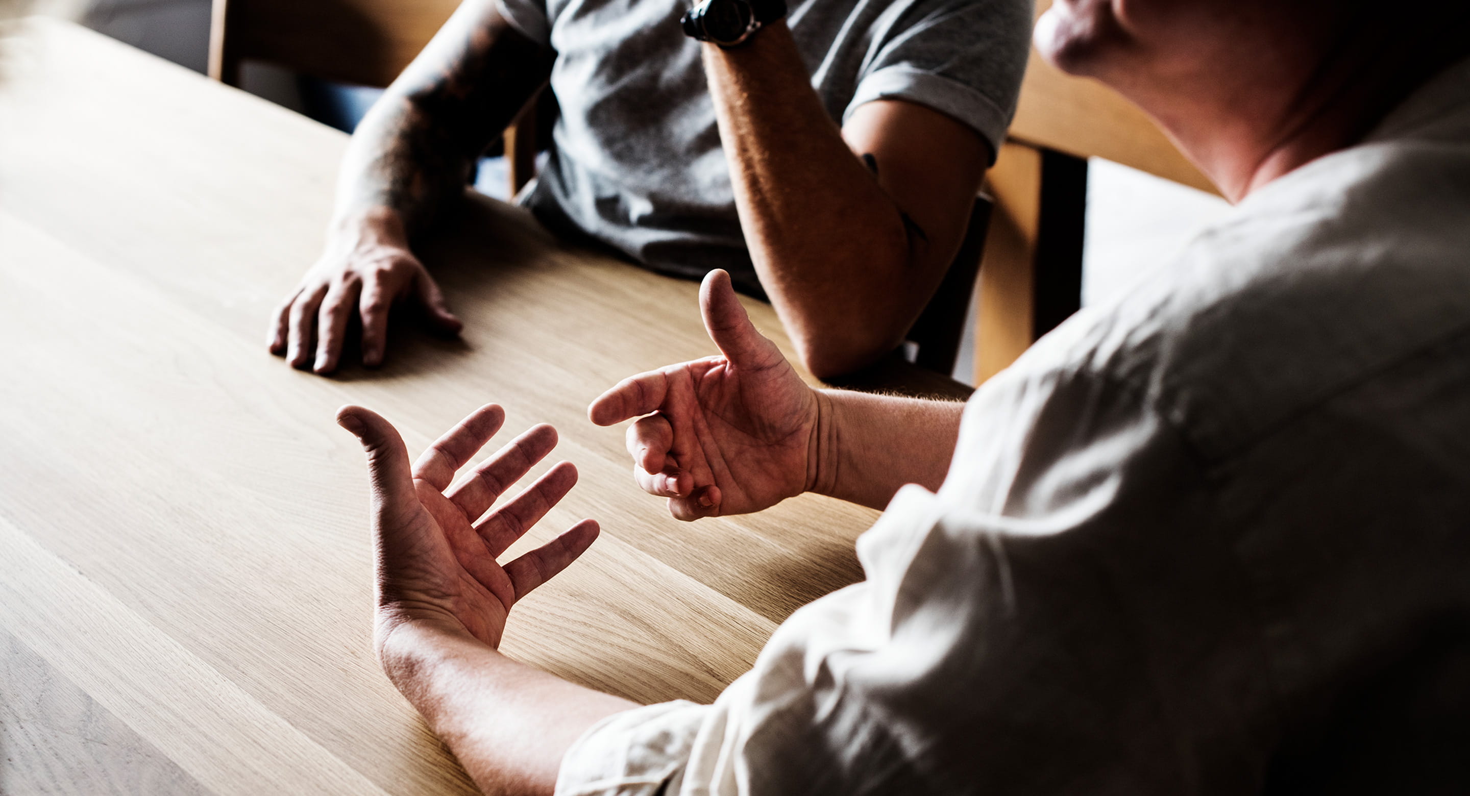 Men sitting at table having a conversation.