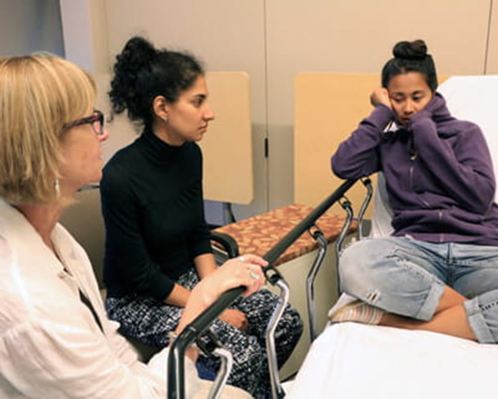 A professional actor plays the part of a teen patient during a mental health simulation. 