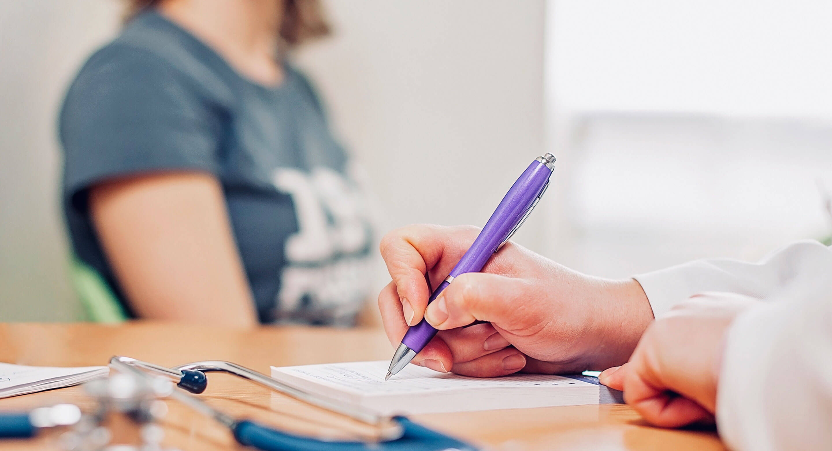 Doctor writing with purple pen