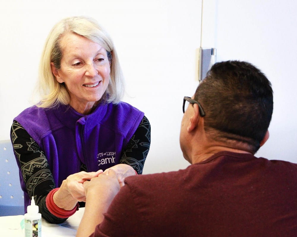 GoL volunteer Lesley Soldat gives one client a hand massage and manicure as part of the self-care event. 