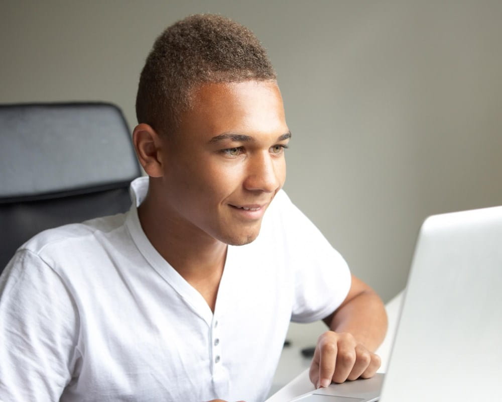 Teen male using laptop