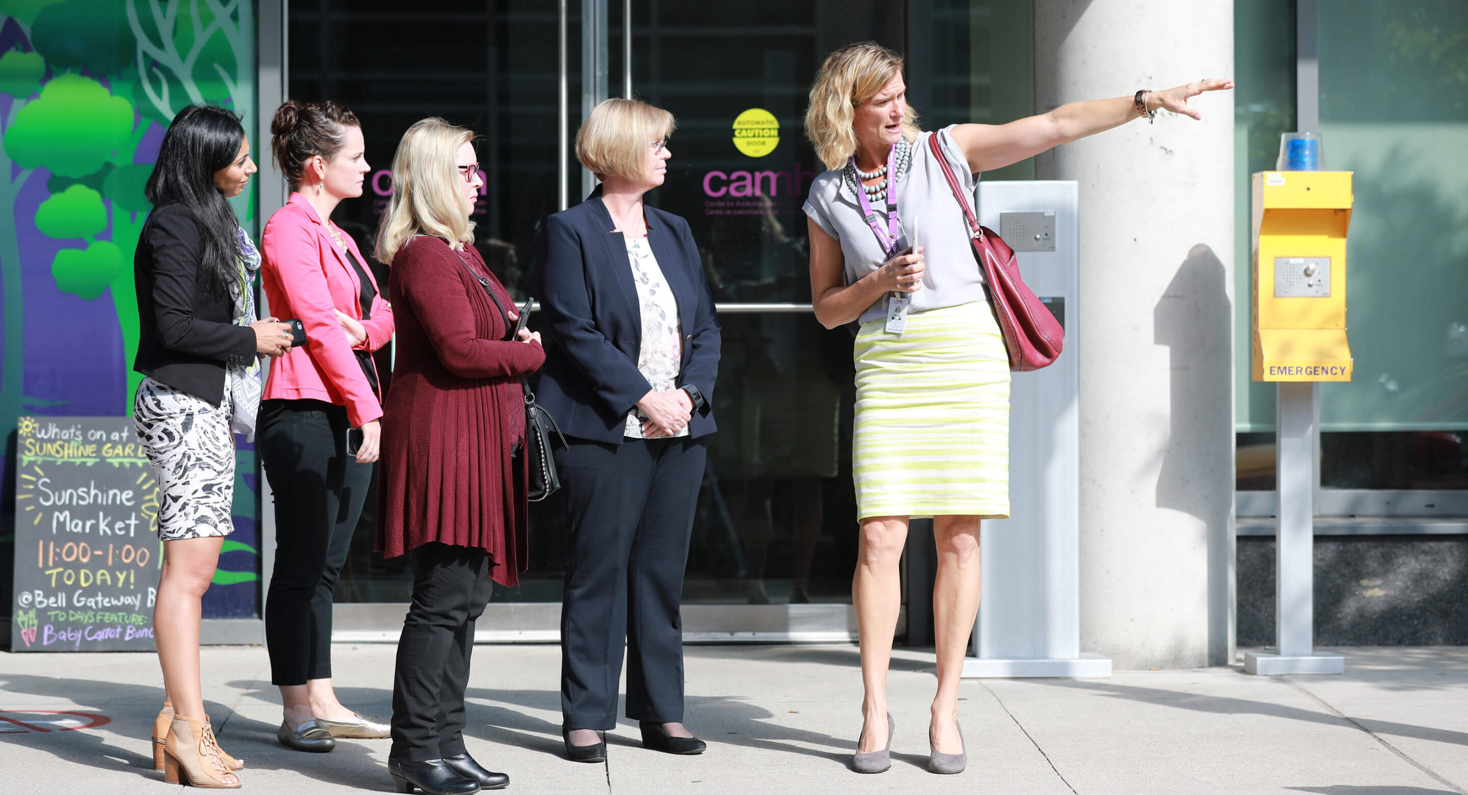 CAMH's Carrie Fletcher points at something near entrance of CAMH building