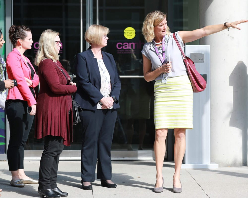 CAMH's Carrie Fletcher points at something near entrance of CAMH building