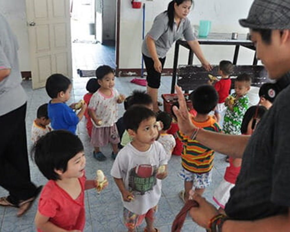 A man visiting an Orphanage filled with young children in Thailand.