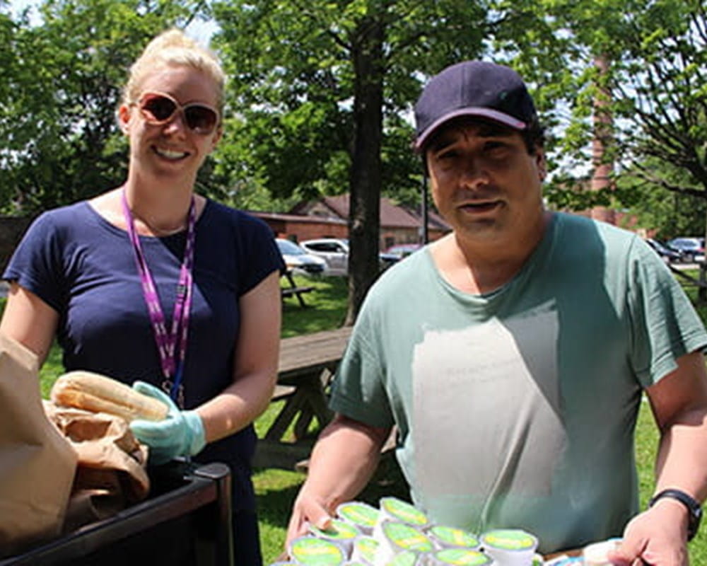 CAMH Recreation Therapist Janine Bakelaar and client Chris Lam get ready to hand out drinks for the CAMH CMI picnic program.