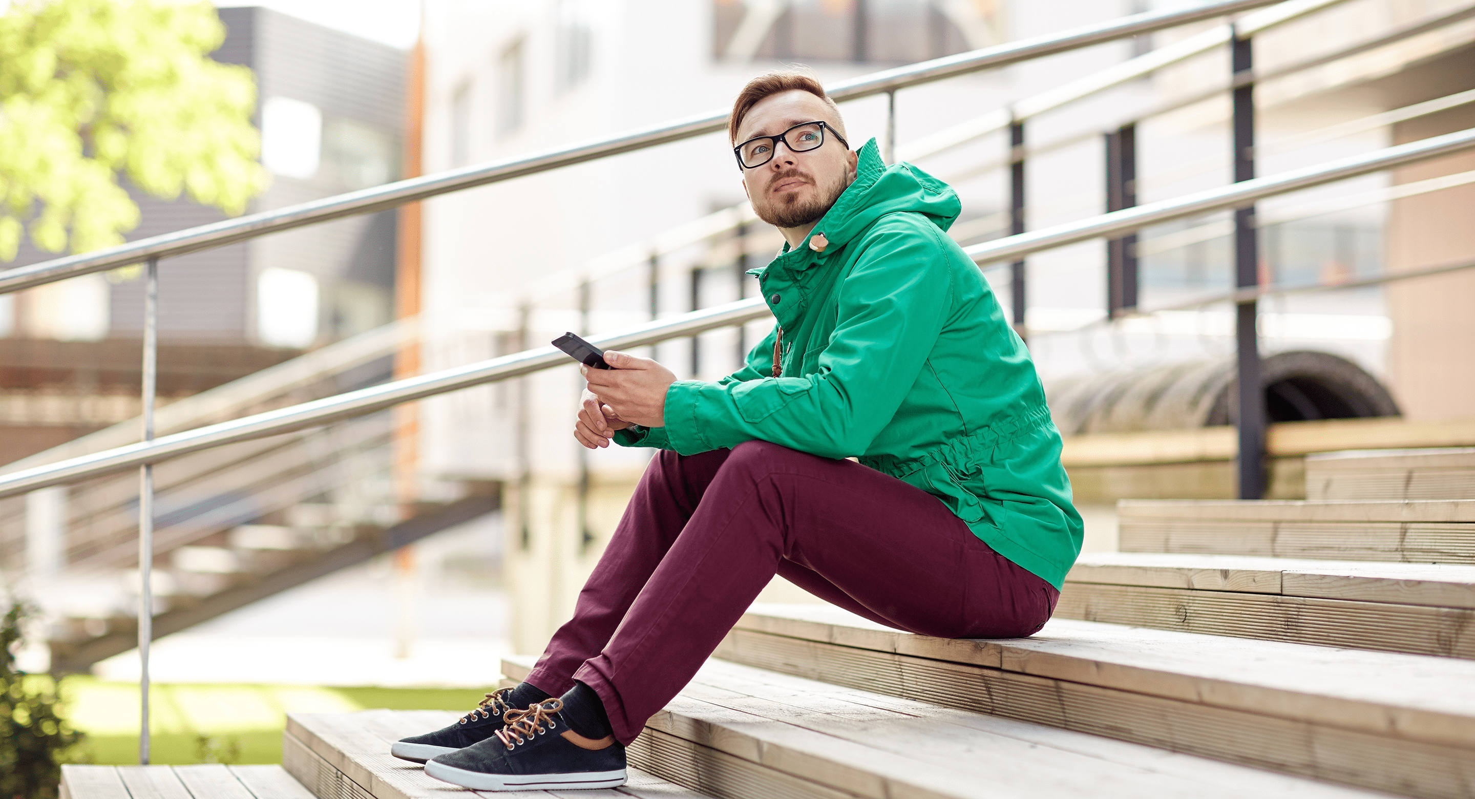young man sitting on steps using smartphone