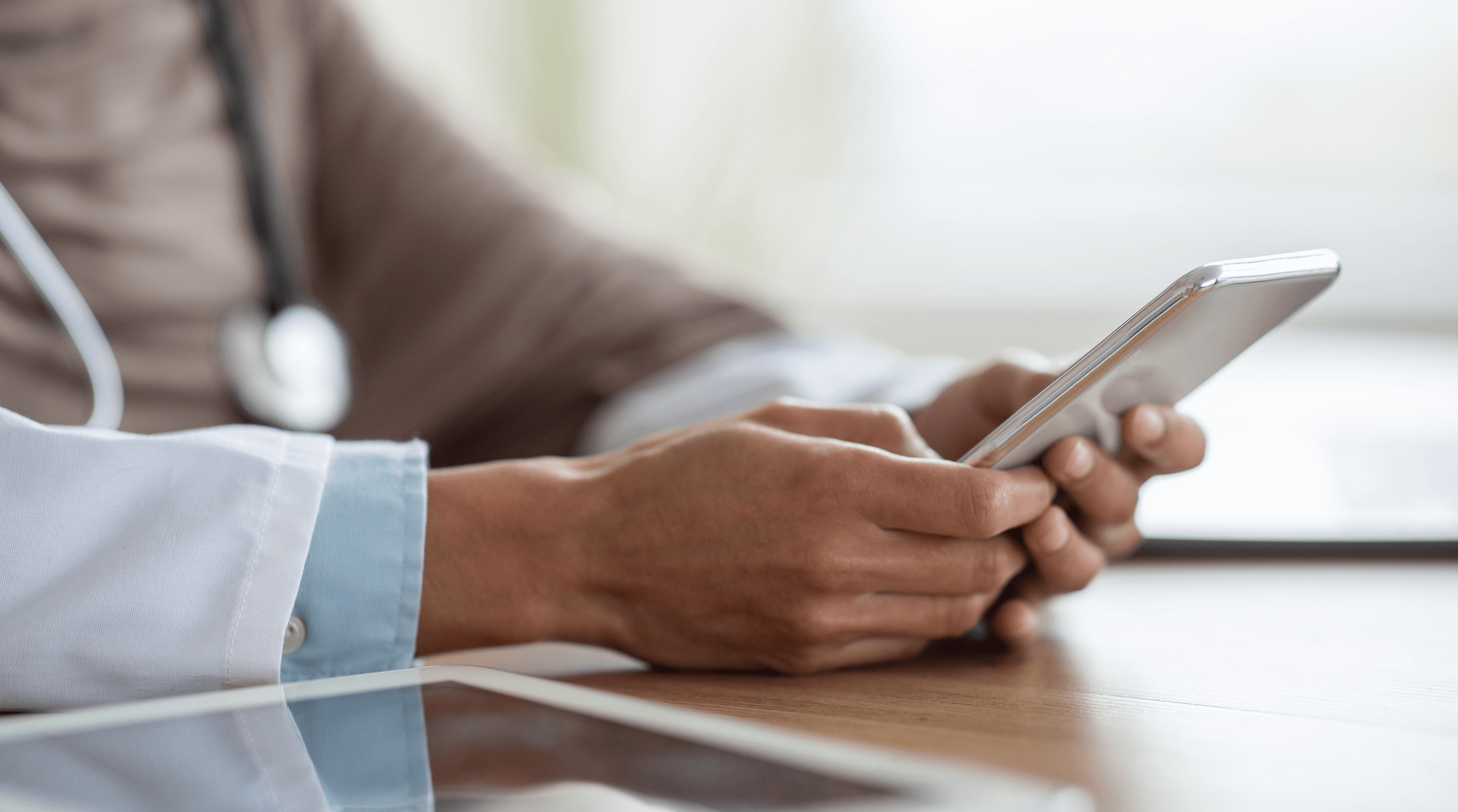 Close up of female doctor wearing a hijab, reading a tablet.