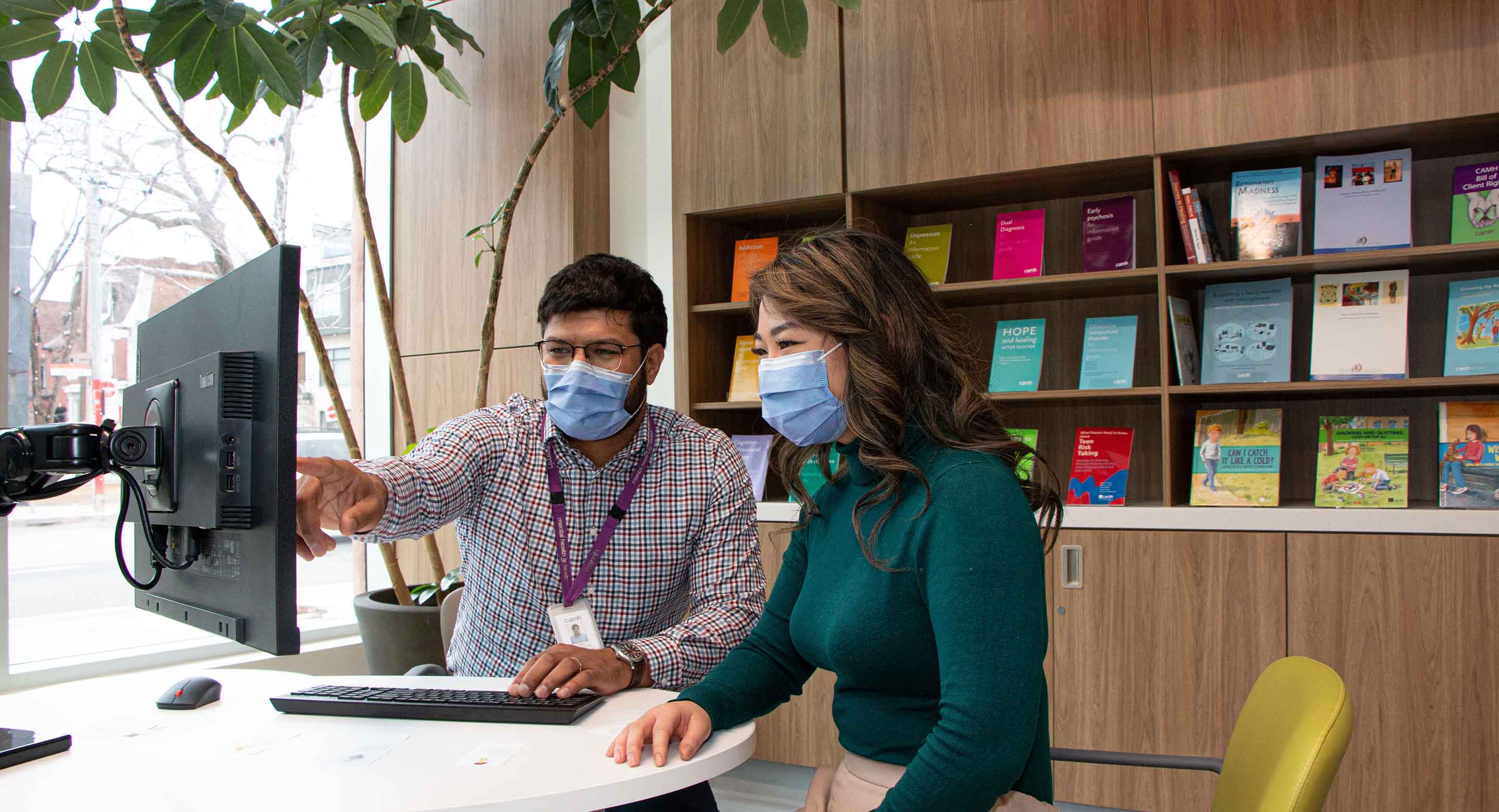 CAMH staff member helping another person on the computer
