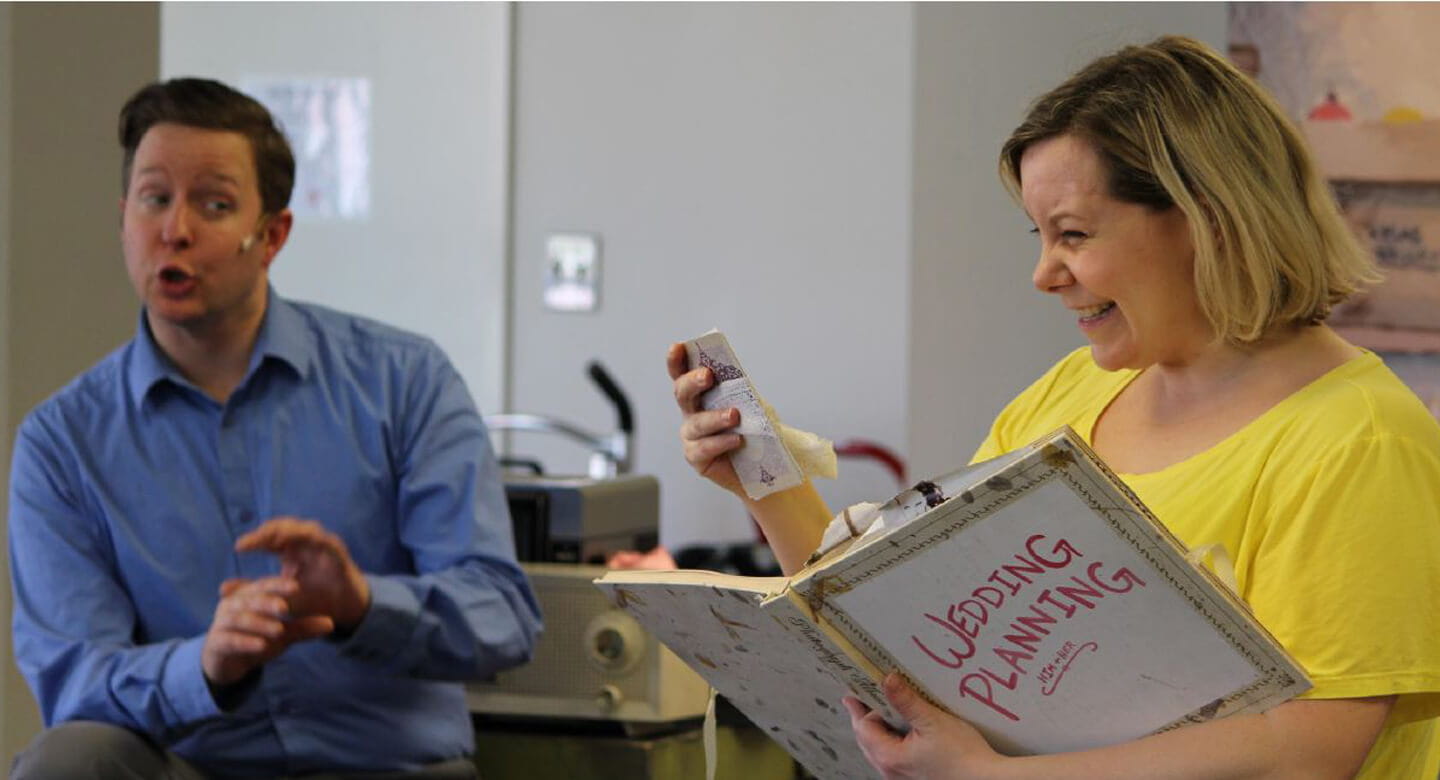 Man singing and woman reading from a book at Smile Serenades