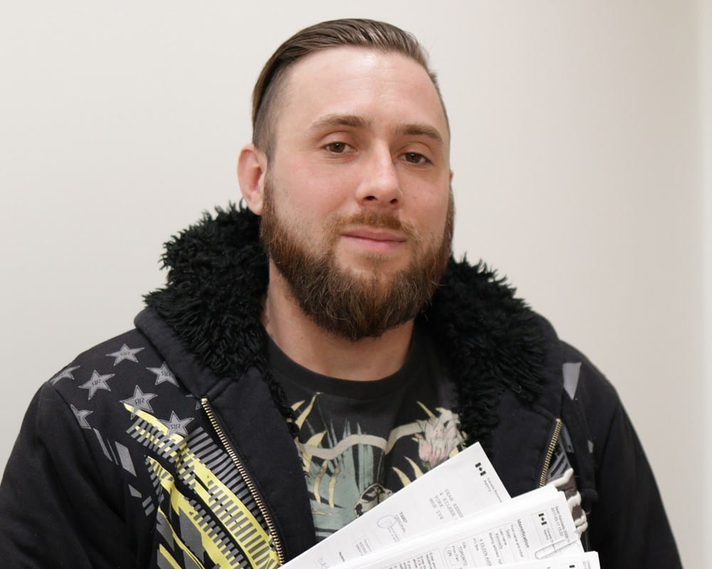 Sean holds up his completed tax forms
