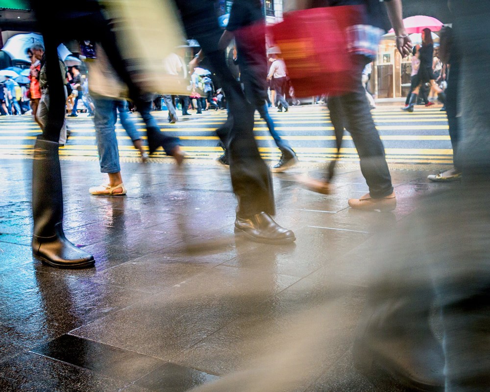 Blurred image focusing on legs and feet of people crossing a street