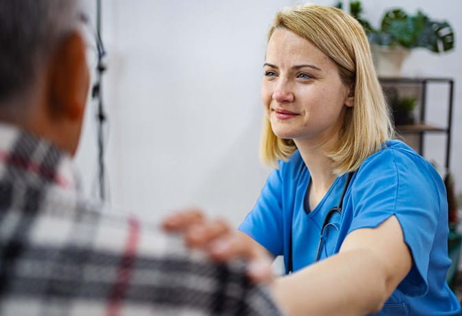Clinician comforts a patient with their hand on the patient's shoulder