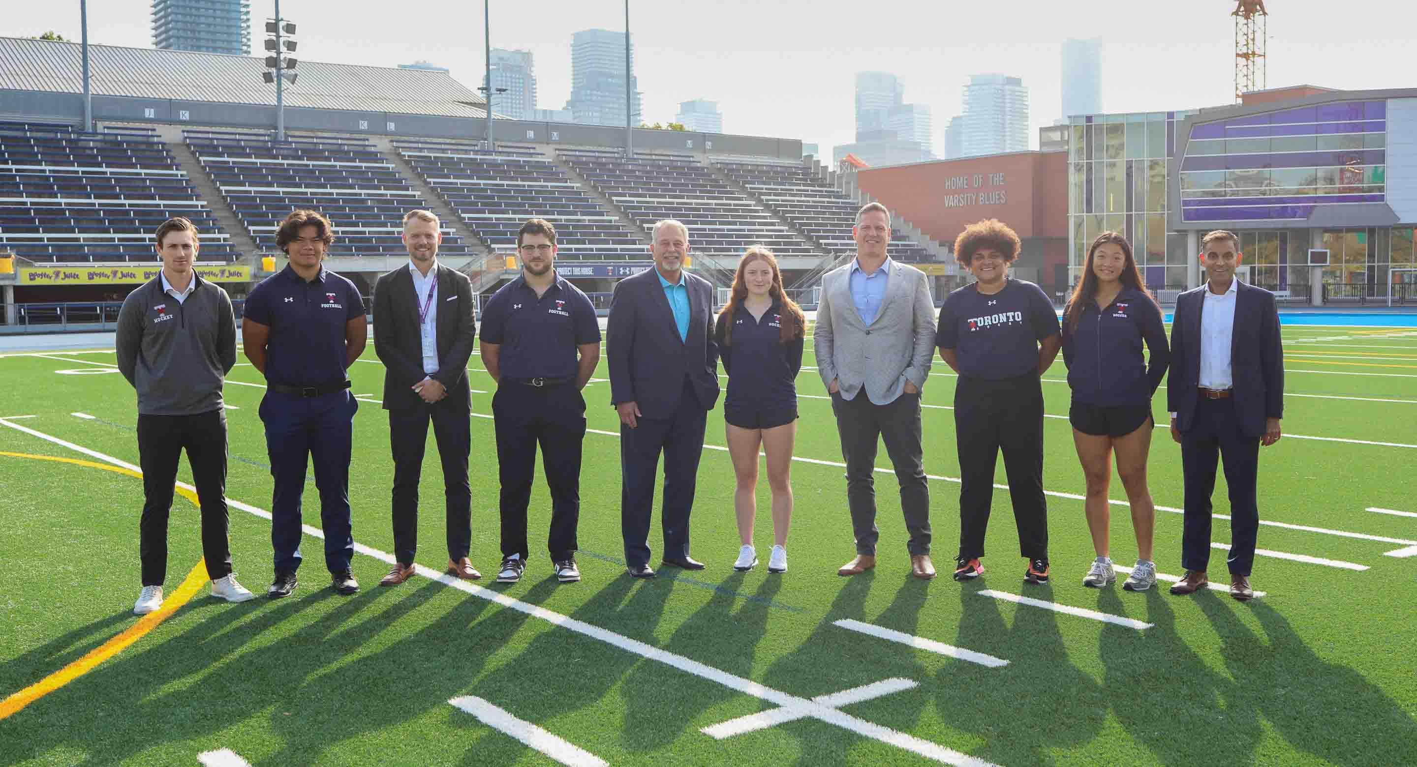 Group photo of Minister Lumsden, Tim Fleiszer, Dr. Neil Vasdev, Dr. Jesse Young, and U of T Student Athletes