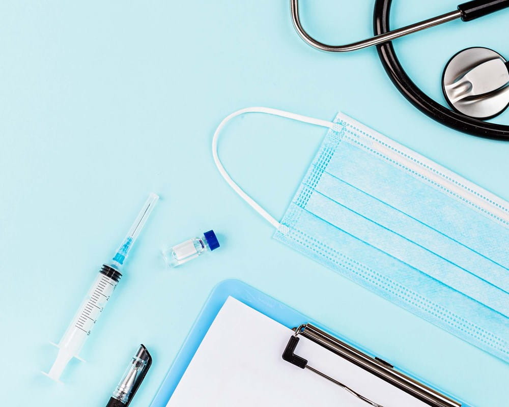 Photo of a syring, vial, mask and stethoscope