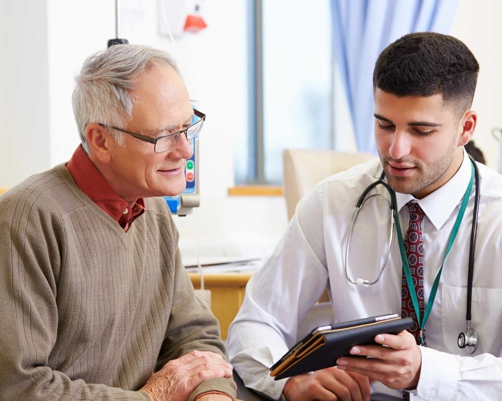 Doctor speaking to a patient while looking at a tablet
